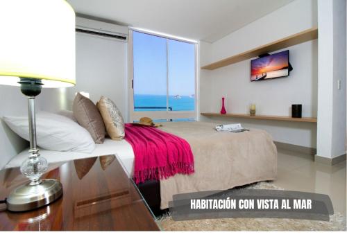 1 dormitorio con cama y ventana con vistas al océano en Apartasuites Reserva del Mar - Frente al Mar by SOHO, en Santa Marta