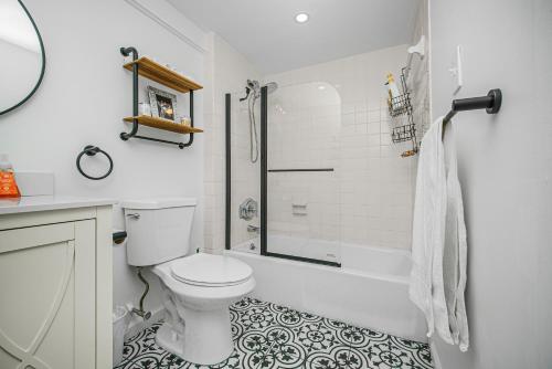 a white bathroom with a toilet and a shower at Oceanfront Jewel - Remodeled to Perfection in Rehoboth Beach