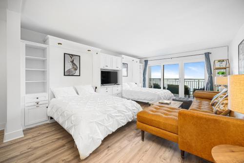 a white bedroom with two beds and a couch at Oceanfront Jewel - Remodeled to Perfection in Rehoboth Beach