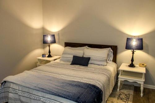 a bedroom with a bed with two lamps on two tables at Game Day Rental in Northport