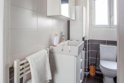 une salle de bain blanche avec un lavabo et des toilettes dans l'établissement Joséphine Cosy - Centre Ville-Pets friendly - Home cinema Netflix - Jardin Privé, à Rueil-Malmaison