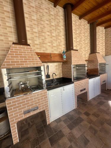 パリョサにあるPousada paraíso Ap próximo ao centro da praia de baixoのレンガ造りのキッチン(シンク、コンロ付)