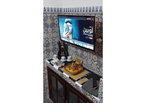 a bathroom with a sink and a tv on a wall at Apartment in Safi Fantastic Near the sea, Morocco in Safi