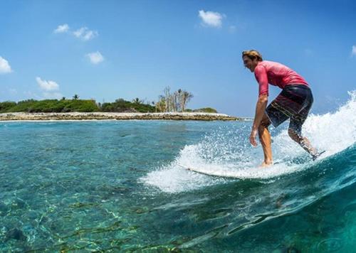 a man riding a wave on a surfboard in the ocean at Buccaneer Bungalow on Amelia Isle! in Fernandina Beach