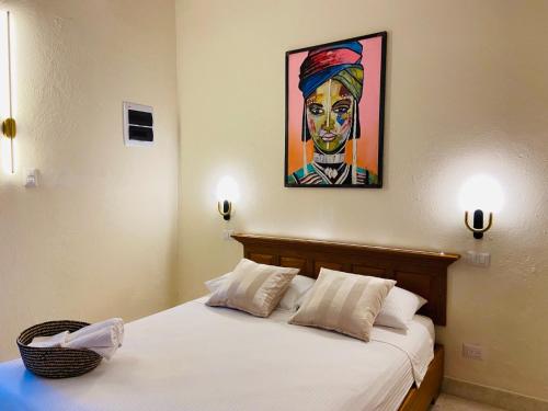 1 dormitorio con 1 cama con una pintura en la pared en Ermitage en Santo Domingo