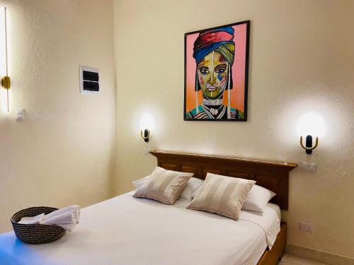 a bedroom with a bed with a painting on the wall at Paseo Colonial - Ermitage #5 in Santo Domingo