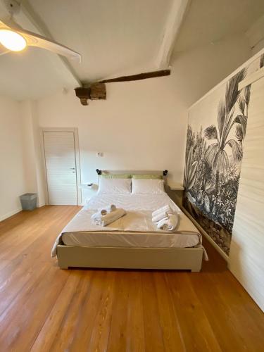 een slaapkamer met een bed en een schilderij aan de muur bij La Matilde in Viareggio