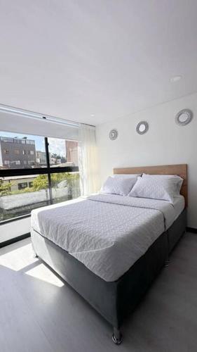 1 dormitorio con cama y ventana grande en Movistar arena 302, en Bogotá
