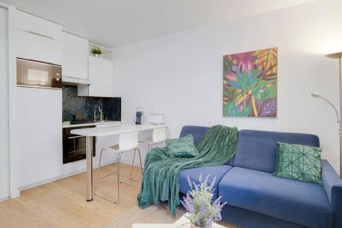 uma sala de estar com um sofá azul e uma cozinha em Le St-Charles#Wifi#TGV em Marselha