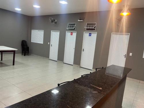 Habitación con 4 puertas blancas y mesa. en Área de lazer espaço Reis, en São José do Rio Preto