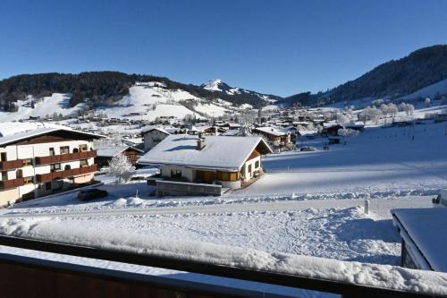 a village covered in snow with mountains in the background at Nicky apartments and studios in Niederau