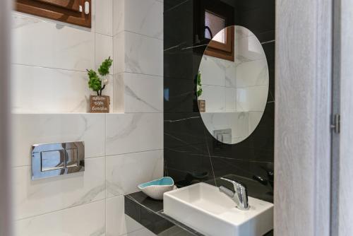 a bathroom with a sink and a mirror at Vacation house with a panoramic sea view and forest in Polychrono