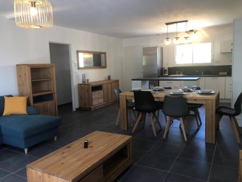 une cuisine et un salon avec une table et des chaises dans l'établissement Le jardin de reine, à Saint-Laurent-de-Carnols