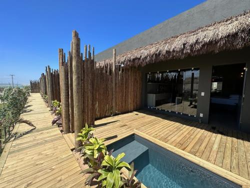 un complejo con piscina y terraza de madera en Vila Flor Studios, en Praia de Moitas