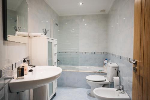 a bathroom with a sink and a toilet and a tub at Casa Losada in Monforte de Lemos