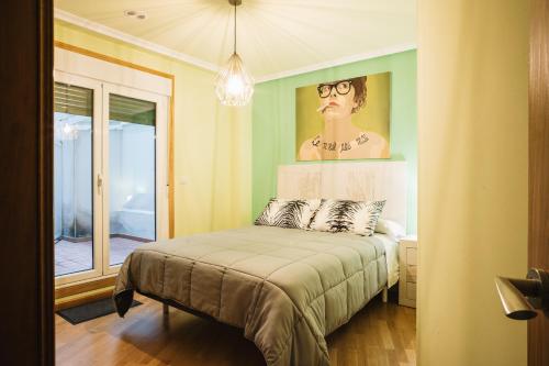 a bedroom with a bed with a painting of a woman at Casa Losada in Monforte de Lemos