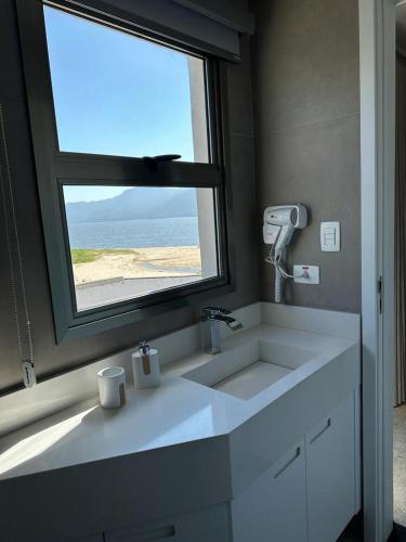 a bathroom with a sink and a large window at Ágape Hotel in São Sebastião
