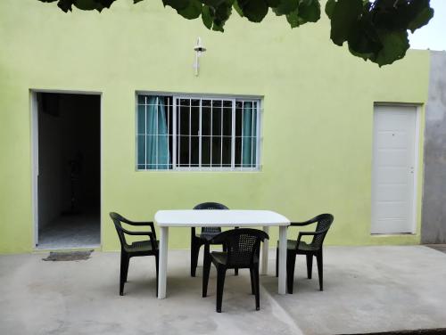 a white table and chairs in front of a building at Atardecer Serrano in Huerta Grande