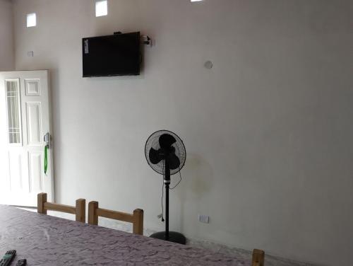 a room with a fan and a tv on a wall at Atardecer Serrano in Huerta Grande