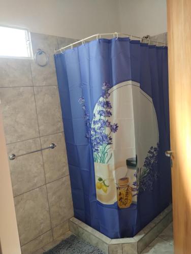 baño con cortina de ducha azul con flores en Atardecer Serrano en Huerta Grande