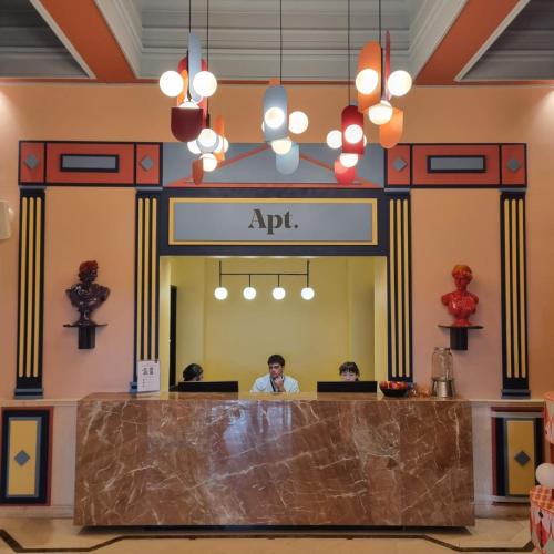 サンティアゴにあるAPT Serviced Apartments Santiagoのロビーの受付デスクに座っている男性