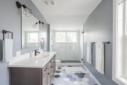 La salle de bains blanche est pourvue d'un lavabo et d'une douche. dans l'établissement Neat Suites, The Baldwin Flatts, à Covington