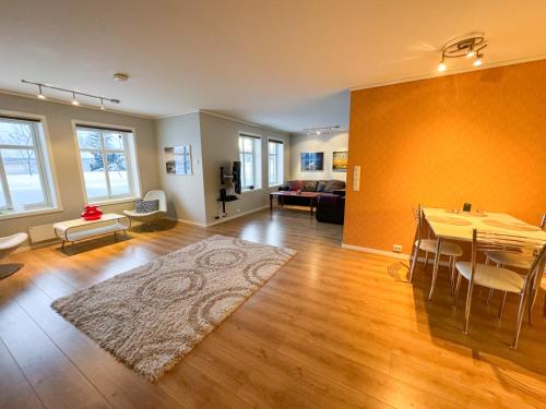 uma sala de estar com uma mesa e uma sala de jantar em Spacious apartment with 3 bedrooms next to amazing nature em Tromsø
