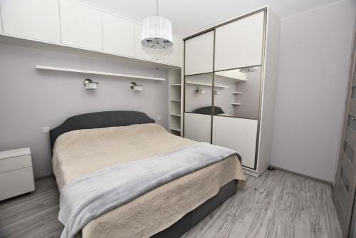a bedroom with a large bed and a closet at Apartament przy Starówce in Elblag