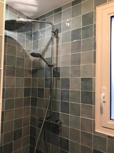 La salle de bains est pourvue d'une douche et de carrelage vert. dans l'établissement Maison face aux îles de Melon, Molène et Ouessant 6P, à Porspoder