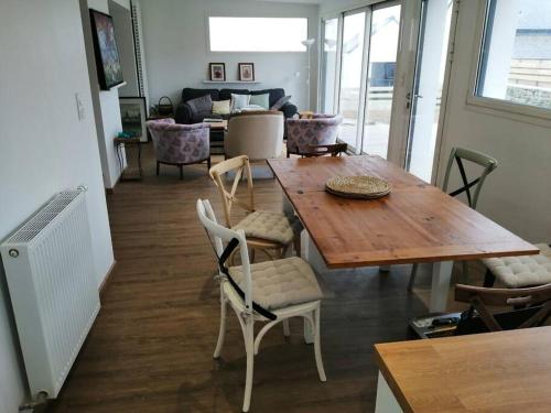 un salon avec une table et des chaises en bois dans l'établissement Maison face aux îles de Melon, Molène et Ouessant 6P, à Porspoder