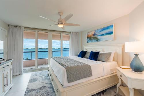a bedroom with a bed and a view of the ocean at Steps to Beach & Pool - Resort Amenities Galore! in Clearwater Beach