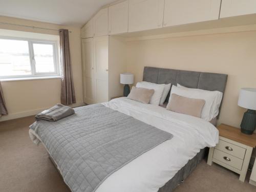 a bedroom with a large bed and a window at Courtyard Cottage in Alnwick