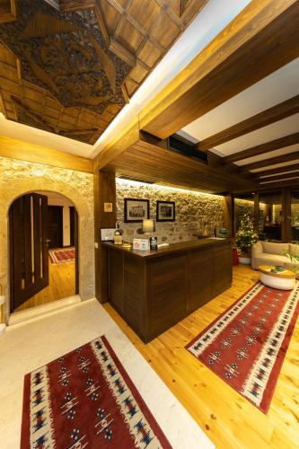 a living room with a kitchen and a rug at Hotel - Kulla e Zenel Beut in Peje