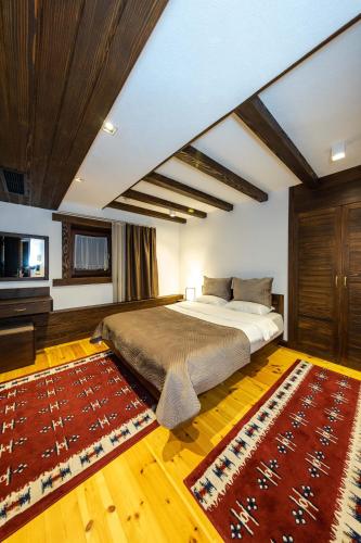 a bedroom with a large bed and a rug at Hotel - Kulla e Zenel Beut in Peje