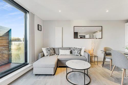 a living room with a couch and a table at Chic Kensal Green Retreat in London