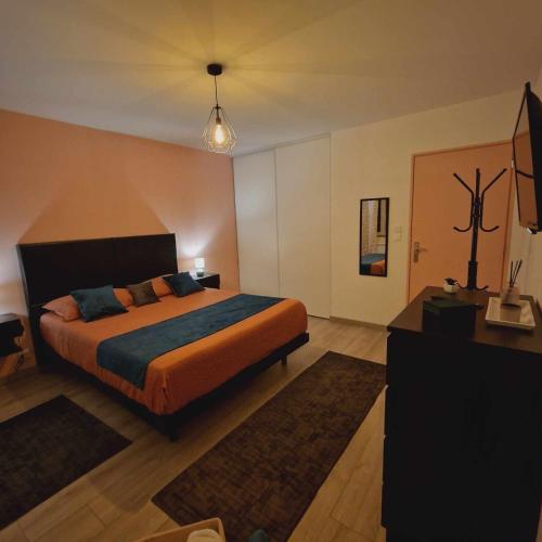 a bedroom with a bed and a television in it at les chambres de Sandra in Volognat