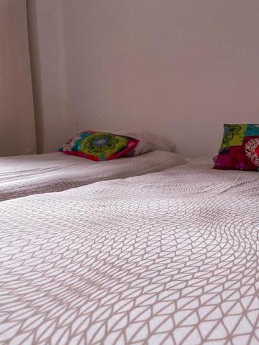 a bed with white sheets and a pillow on it at Gite Des Lacs Jumeaux in Clairvaux-les-Lacs