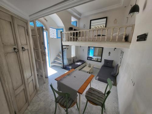 a living room with a staircase and a table and chairs at Beautiful studio in the center of sidi bou said village in Sidi Bou Saïd