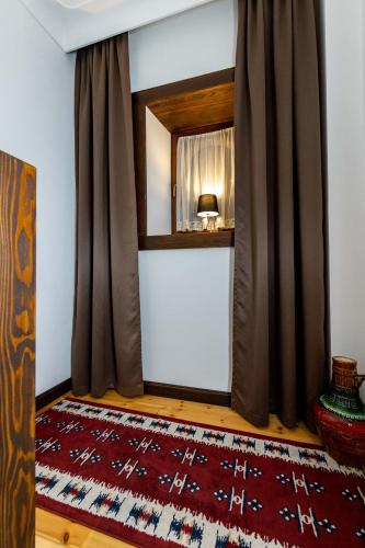 a room with a curtain and a red rug at Hotel - Kulla e Zenel Beut in Peje
