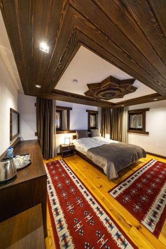 a bedroom with a large bed and a large rug at Hotel - Kulla e Zenel Beut in Peje