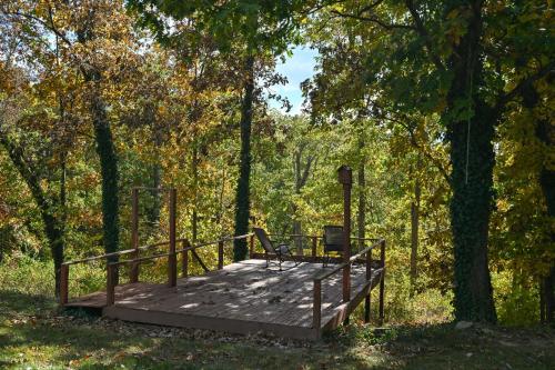 eine Holzbrücke mit einer Bank darauf im Wald in der Unterkunft Sleeps 12, Wooded Lot, Near Ark, Great for Family in Williamstown