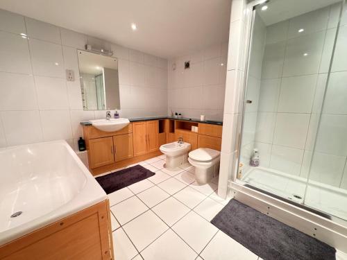 y baño con aseo, lavabo y ducha. en Spacious and Refreshing 3-4 Bed Stamford House! en Stamford