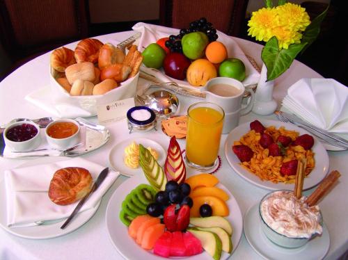 a table topped with plates of food and fruit at Antara Hotel & Suites - Miraflores in Lima