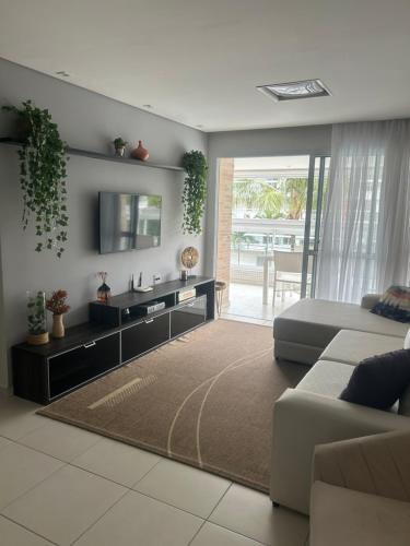 a living room with a couch and a television at Apartamento na Riviera de Sao Lourenco in Riviera de São Lourenço