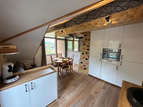 une cuisine avec une table et une salle à manger dans l'établissement LES CIMES DE CADELIO , 5 à 7 personnes, Proche base de loisirs et remontée du pontillas, Dernier étage, à La Salle Les Alpes