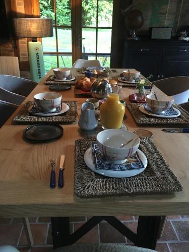een houten tafel met borden met eten erop bij Il Était Autrefois in Saint-Hellier