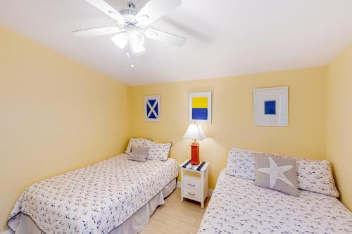 a bedroom with two beds and a ceiling fan at Canalside at KCB in Key Colony Beach