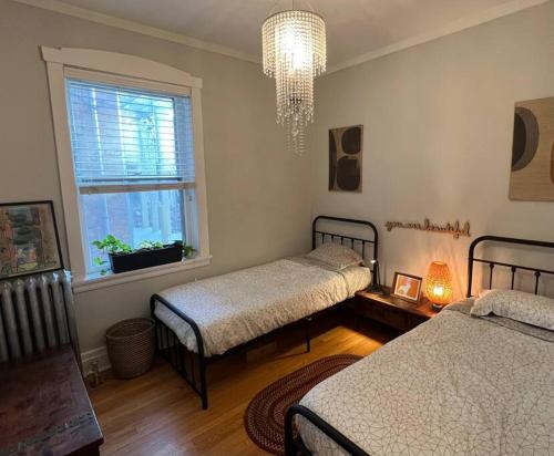 a bedroom with two beds and a chandelier at In Andersonville on Balmoral in Chicago