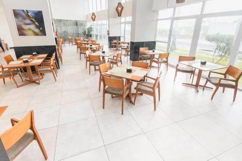 a dining room with wooden tables and chairs at Silverton Paiva Experience in Recife