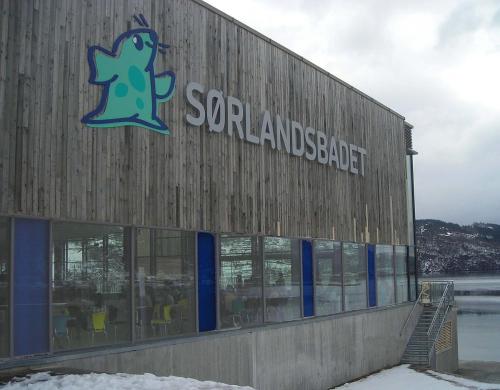 a building with a sign on the side of it at Gauvik - Lyngdal in Lyngdal